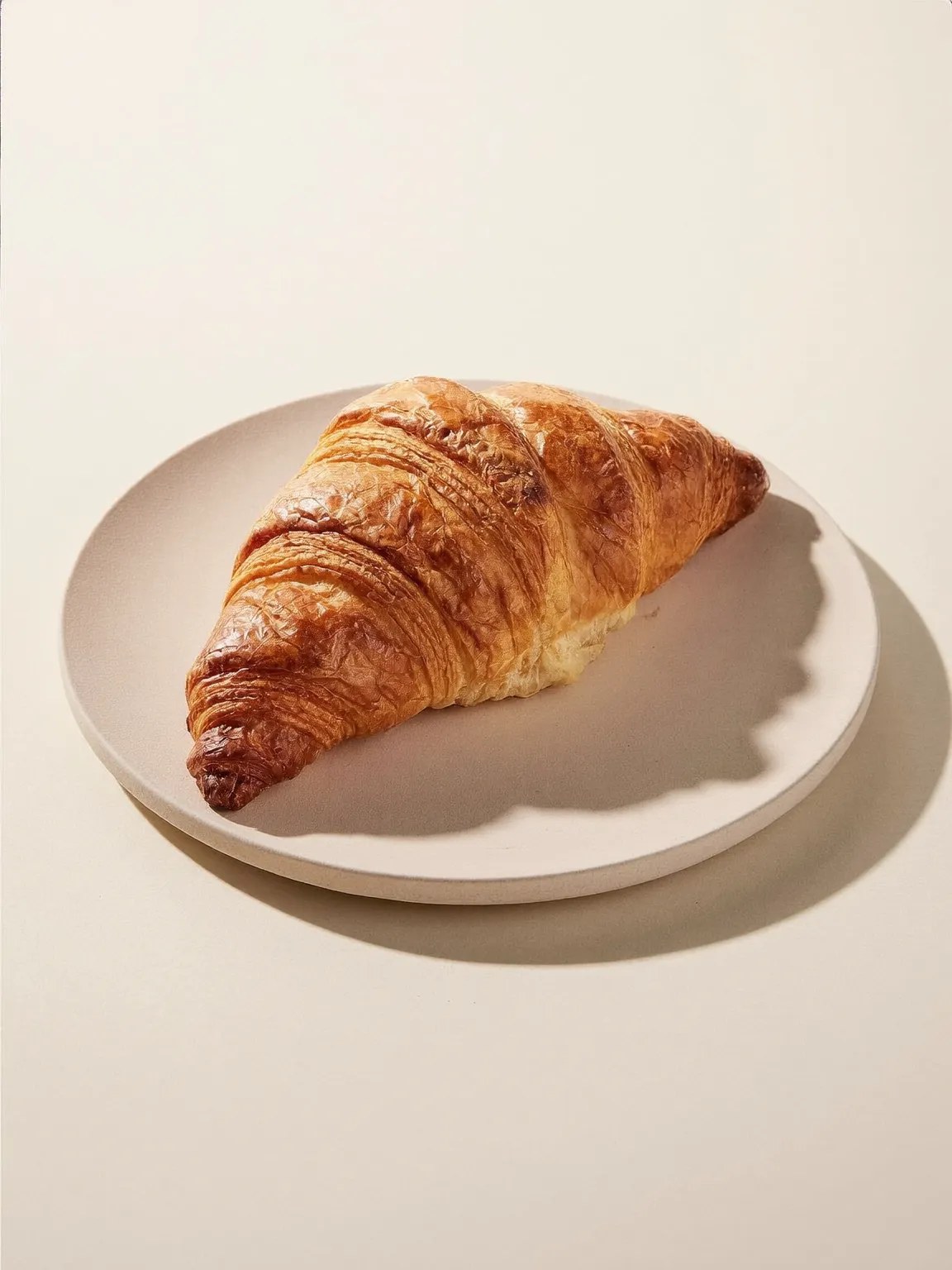 A butter croissant on a small plate